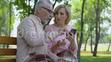 老人帮助<strong>老伴</strong>使用智能手机，快乐的老夫妇一起在公园里